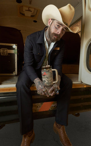 Post Malone Sitting On The Back Of Bus Holding Stanley Tumbler Cup